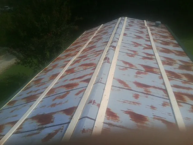 Rusted metal roof panels with new wood purlins before replacement — Storm Damage Roof Repair in Woolstock by Roofing Brothers