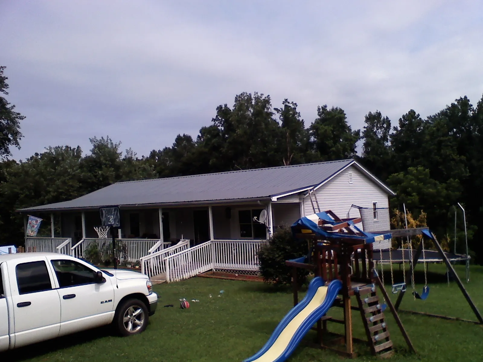 Dark metal roof on a country home with a full length front porch in Woolstock