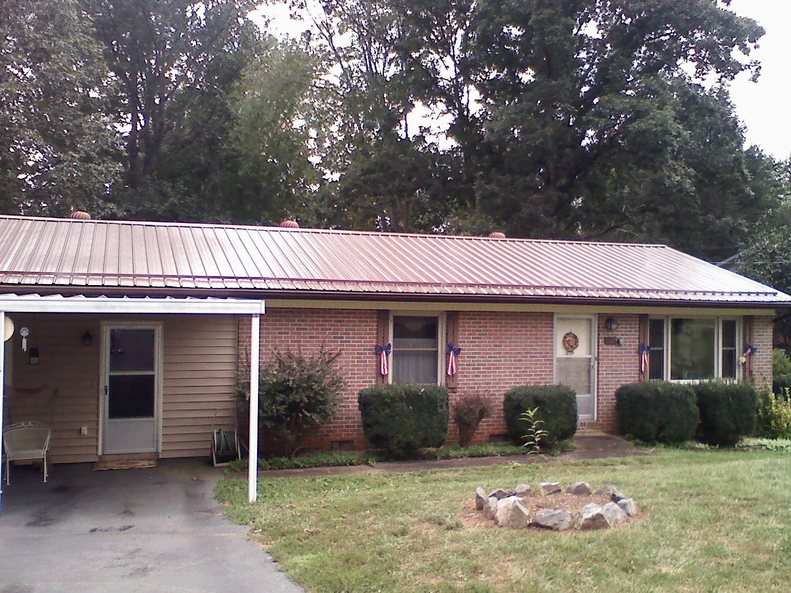 Bronze metal roof and carport on a brick ranch home — Roof Repair work by our crew in Woolstock