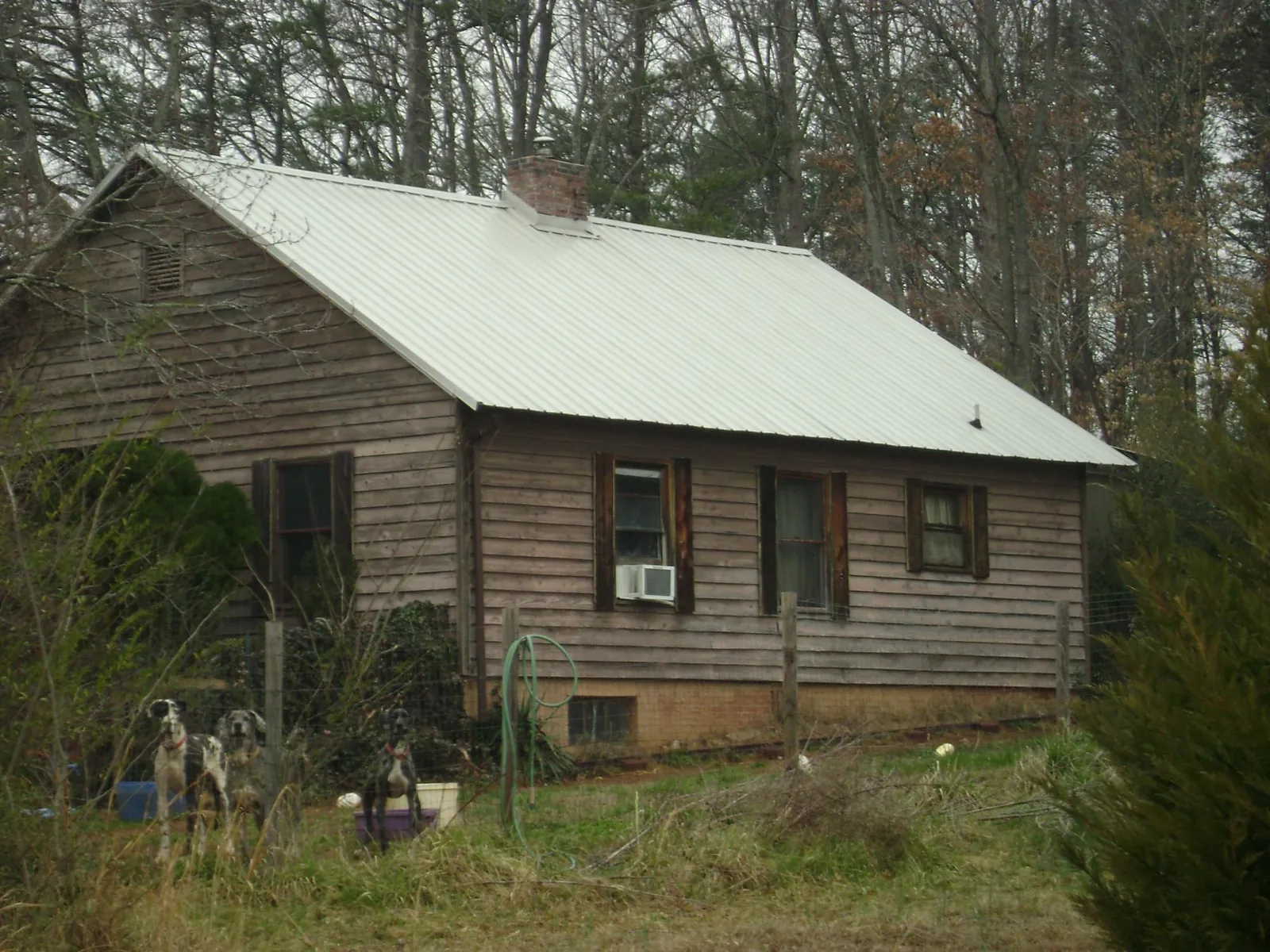 White metal roof on an old wood sided farmhouse, from a Metal Roof Installation job in Woolstock